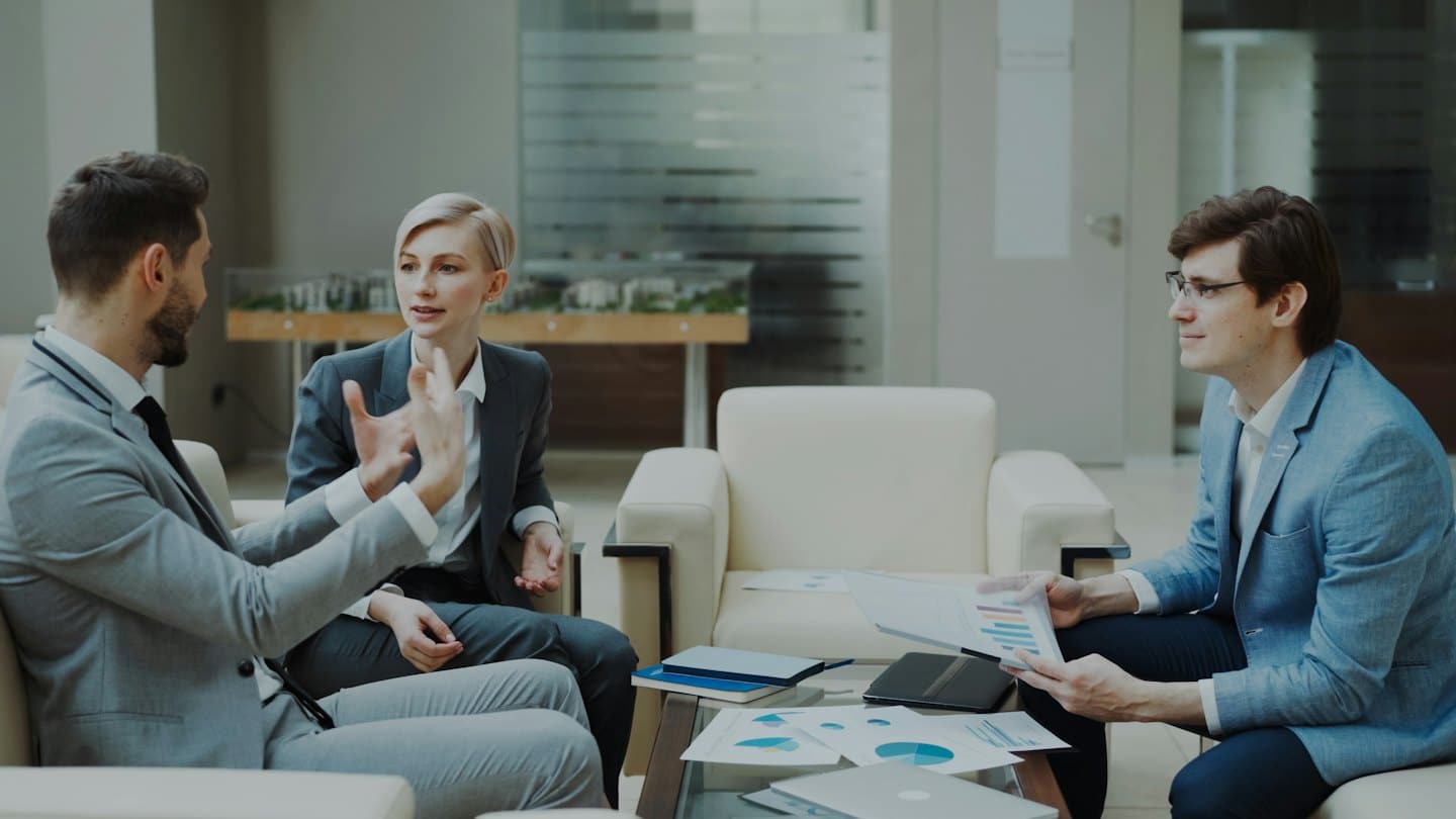 Professionisti aziendali che discutono di strategia in un moderno salotto d'ufficio.